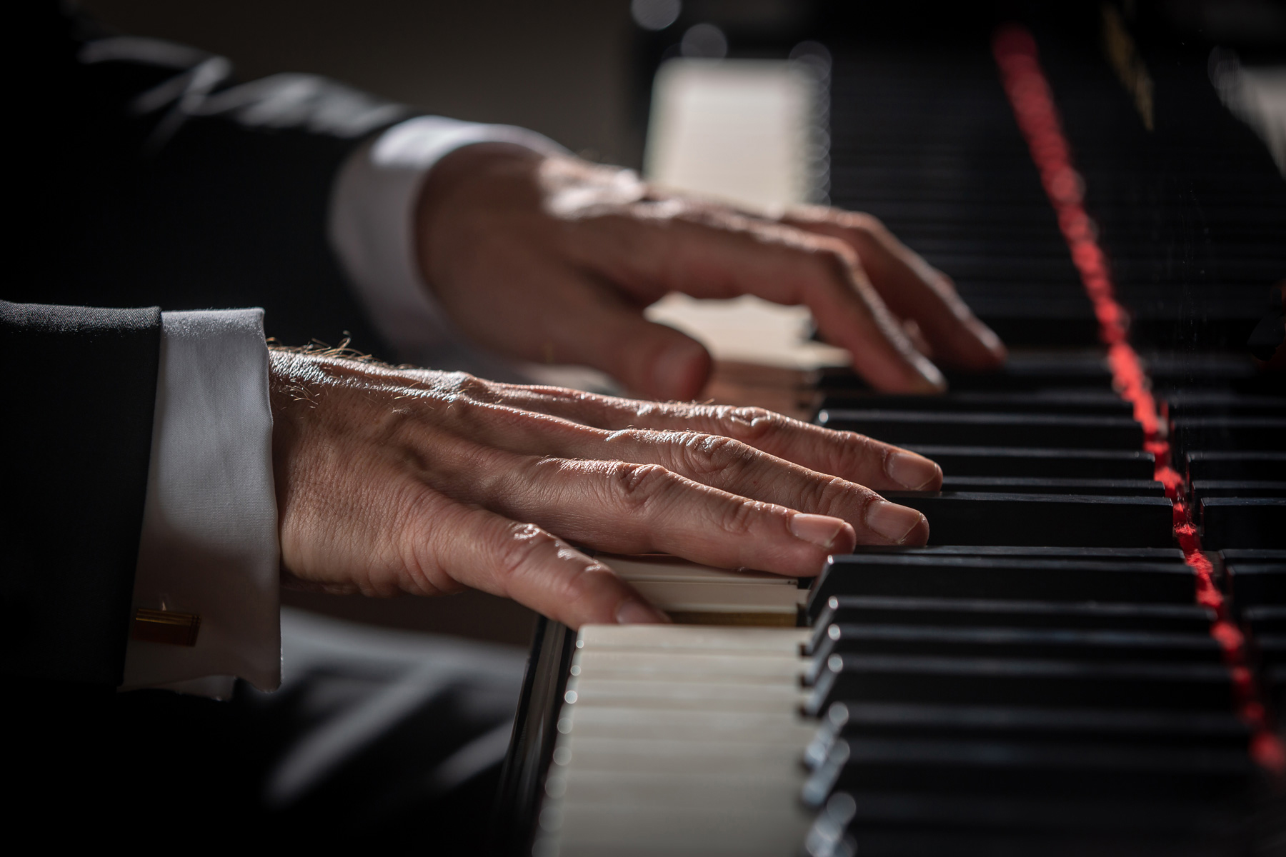 Die Hände von einem Pianisten am Klavier